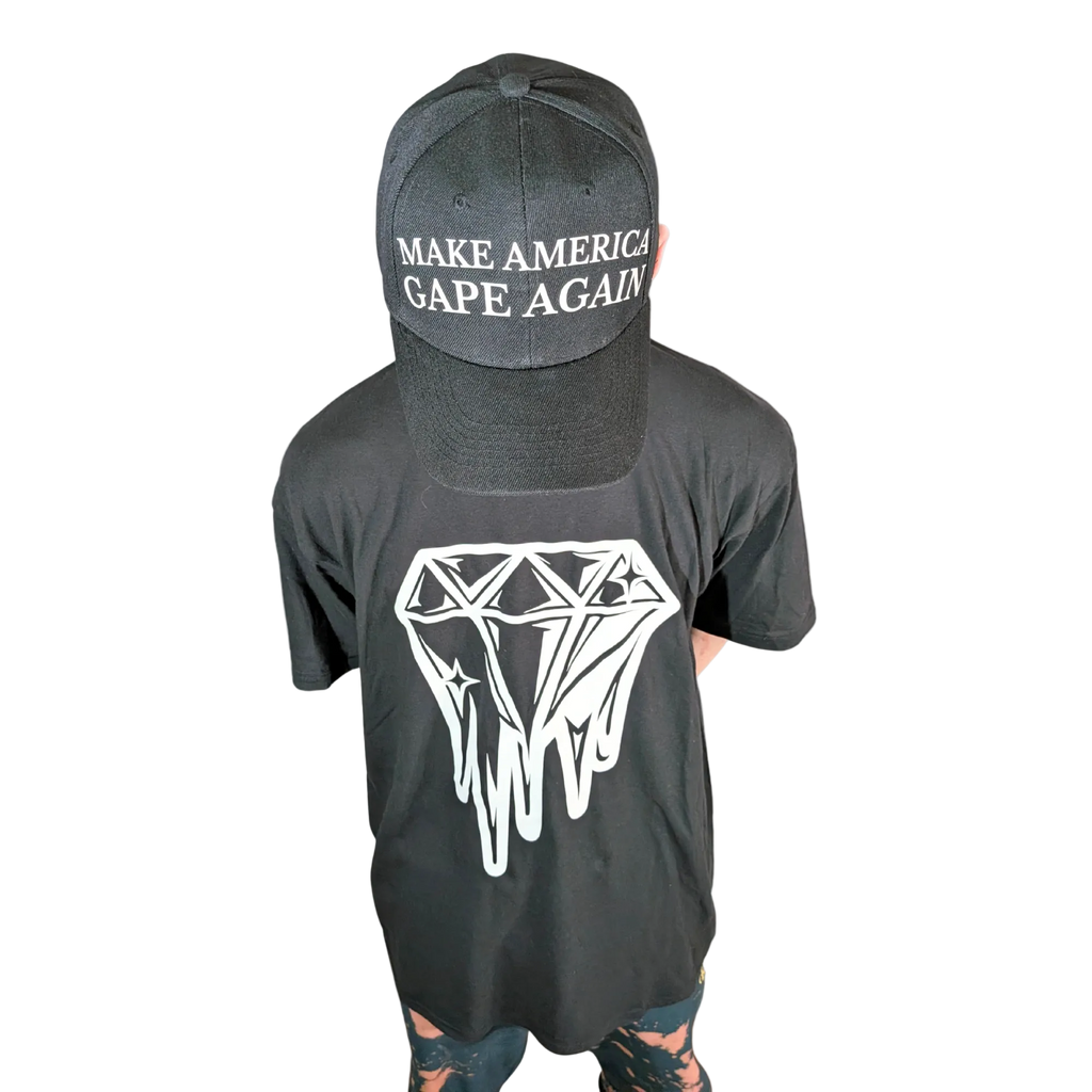 Person wearing a black t-shirt with a diamond graphic and a cap with text on a white background