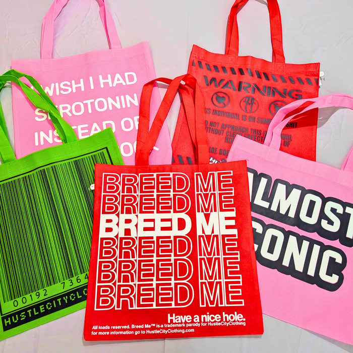Colorful tote bags displaying Hustle City Clothing artwork and typography-based designs.