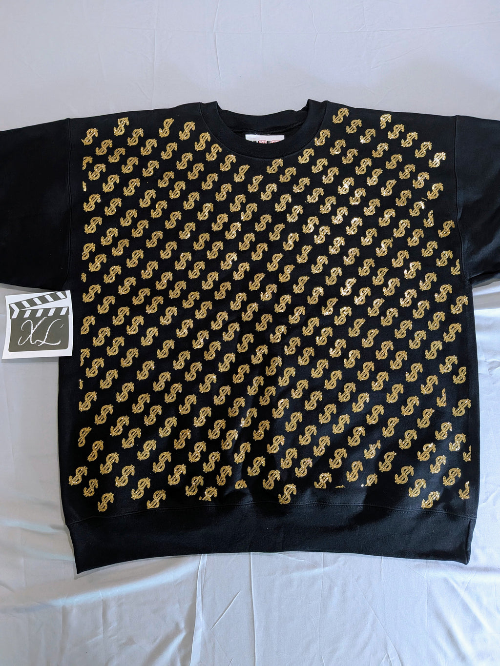 Black sweater with gold pattern on a white background