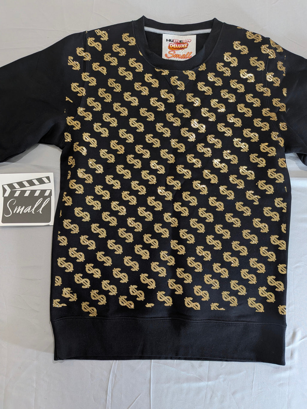 Black sweater with gold pattern on a white background